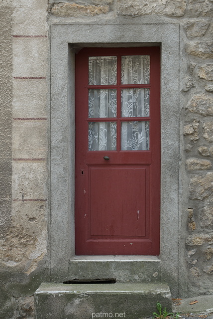Photographie d'une porte dans le mur en pierres d'une maison ardchoise