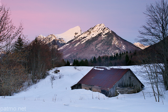 Photo d'une vieille grange dans un paysage d'hiver au crpuscule dans le Parc Naturel Rgional du Massif des Bauges