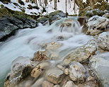 Photographie de petites cascades entre rochers et glaons dans la rivire de la Valserine