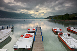 Photo of Annecy lake under a cloudy sky by an autumn morning